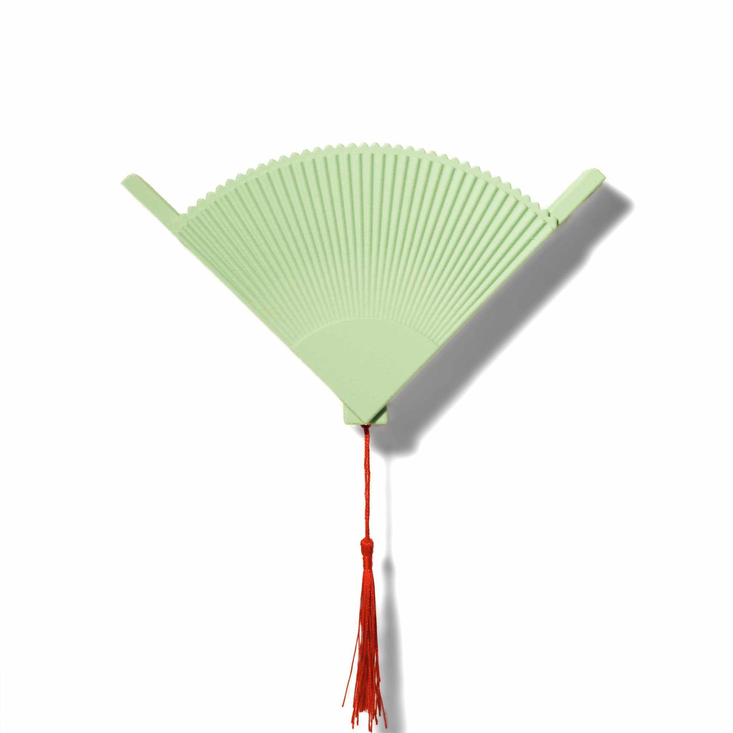 Light green coffee filter holder with a red tassel on a white background
