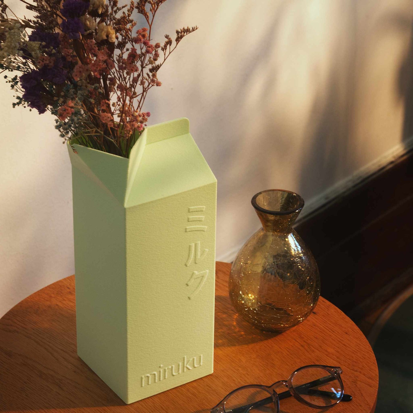mint green 2L milk carton vase holding dried flowers displayed on table