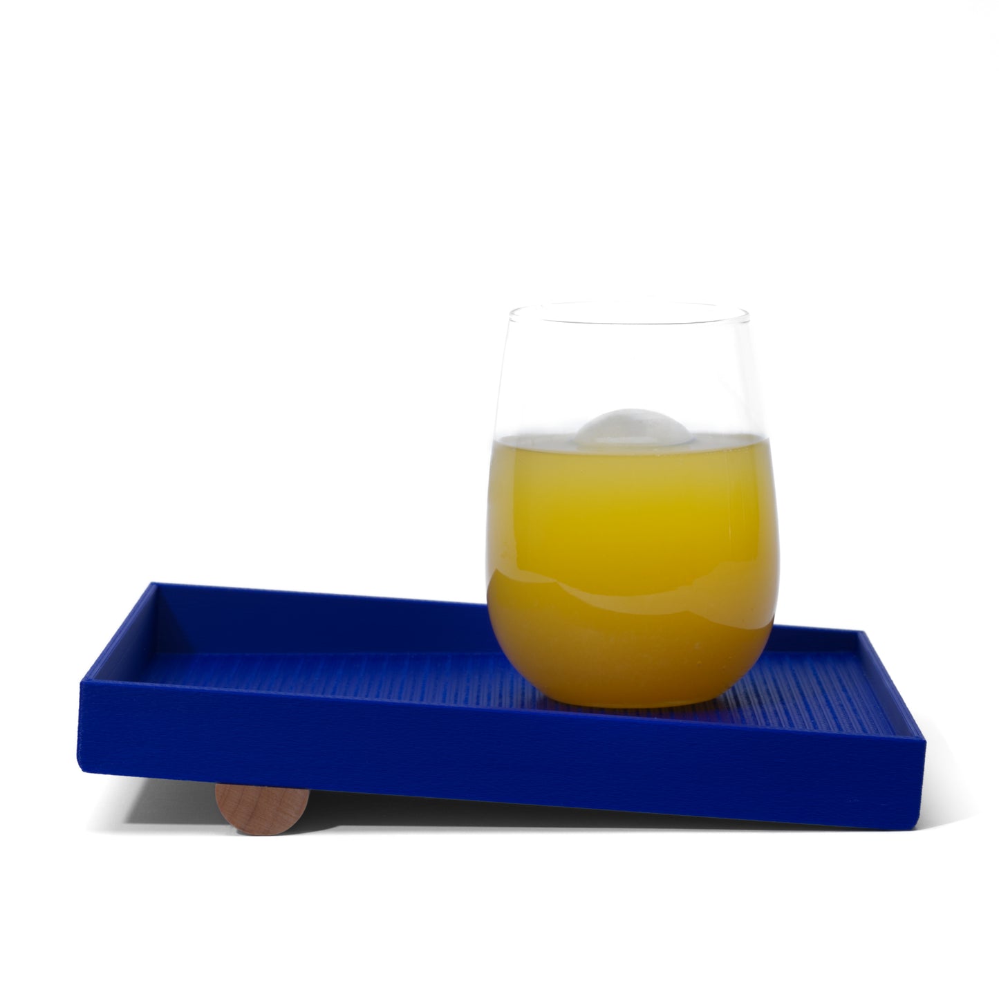 blue catch-all tray with a glass of orange juice on it