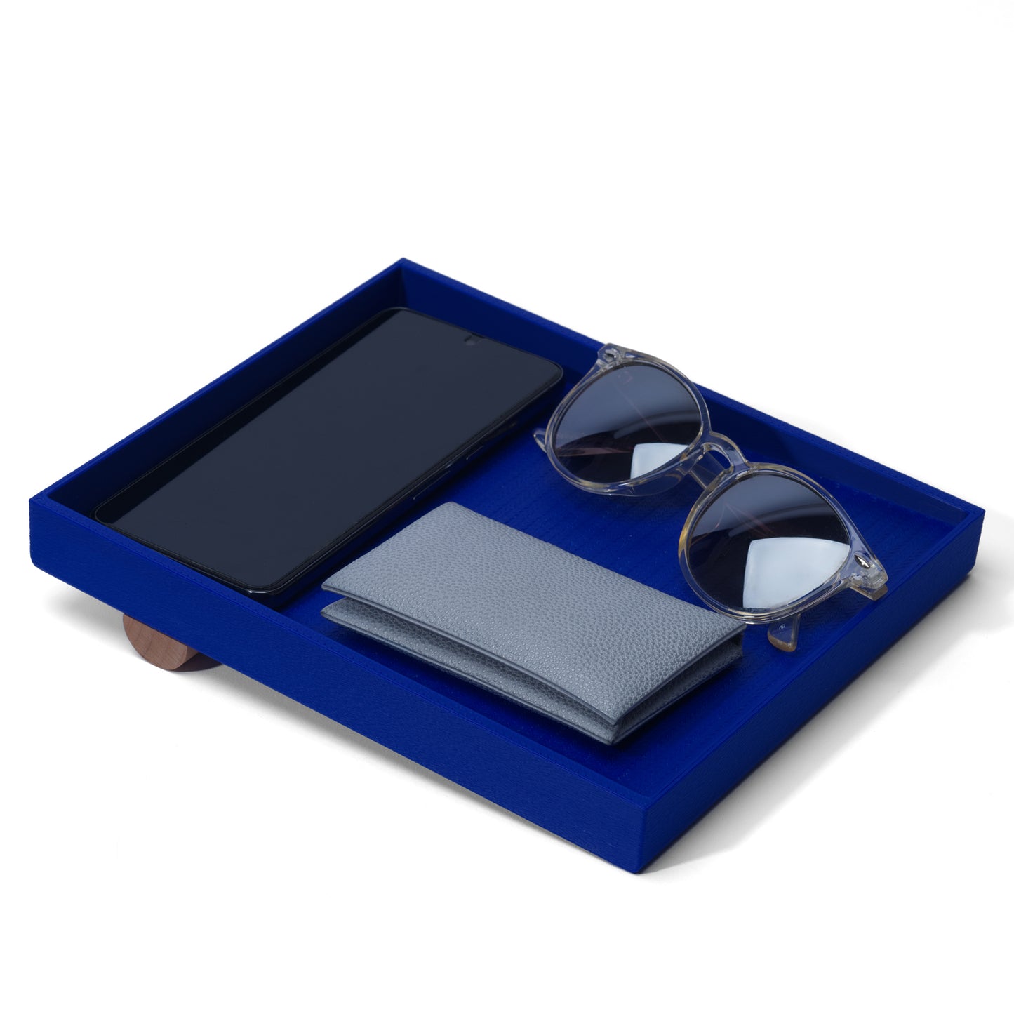 blue catch-all tray containing a cellphone, sunglasses, and a wallet