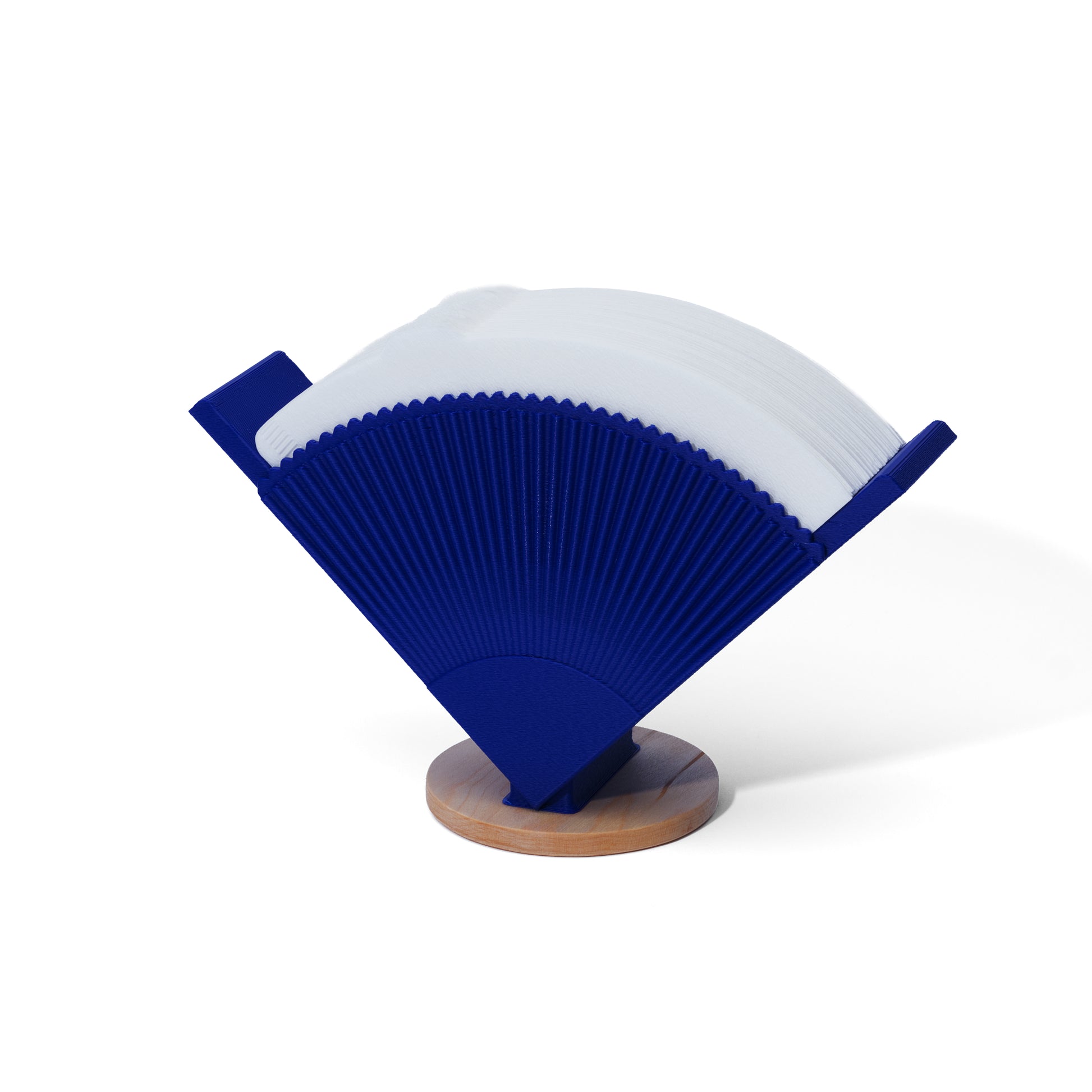 Blue coffee filter holder filled with V60 coffee filters with a wooden base on a white background