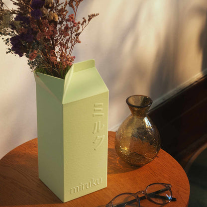 mint green 2L milk carton vase holding dried flowers displayed on table