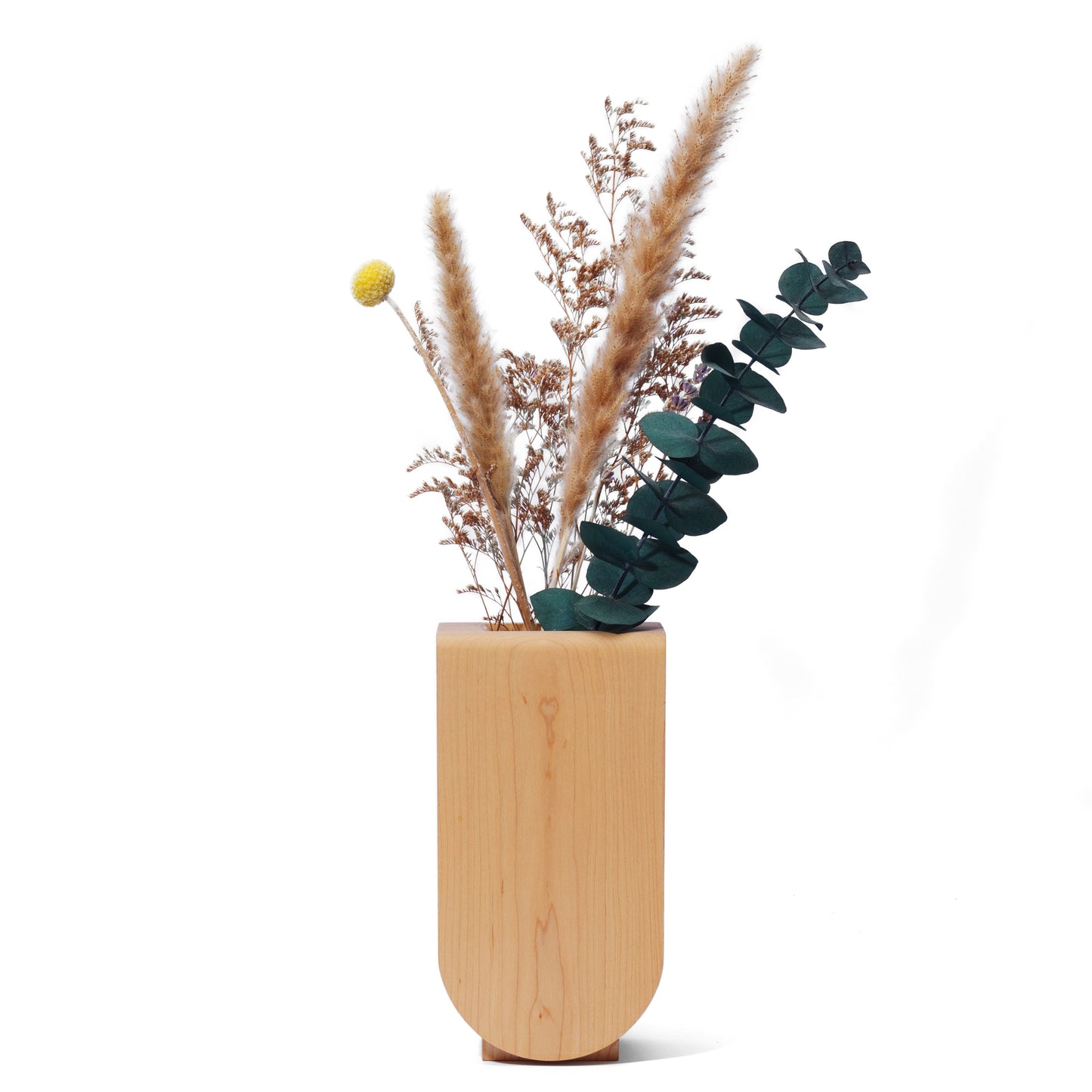 Handmade wooden vase with dried plants in it on a white background