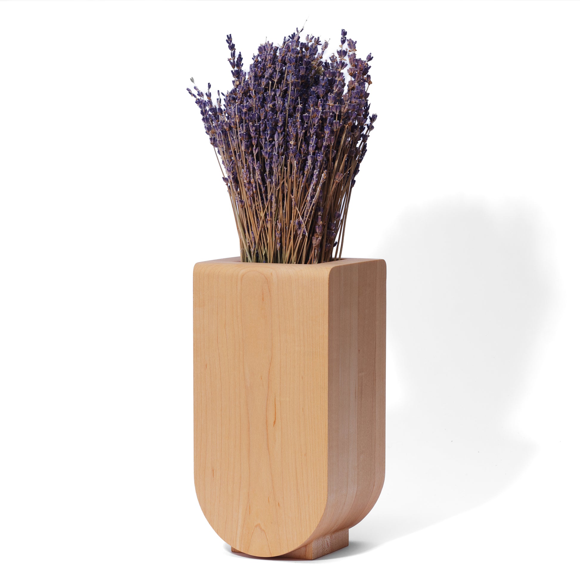 Handcrafted wooden vase with a bouquet of dried lavender in it displayed on a white background